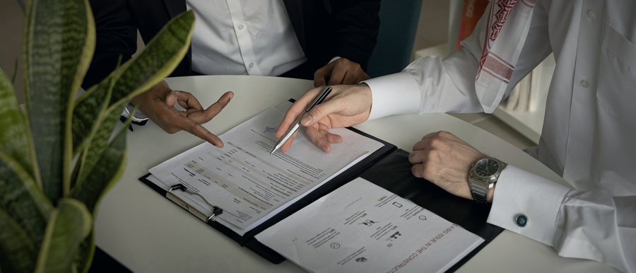 Two people reviewing and signing a contract across a table